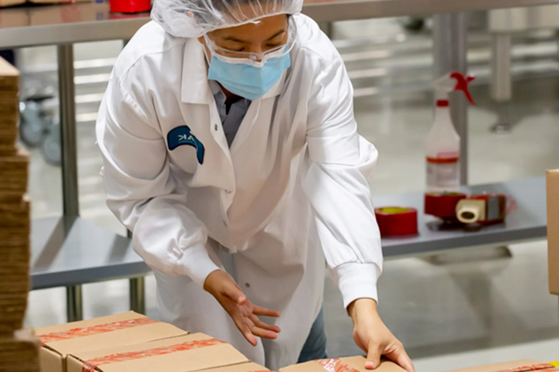 Peak employee working with packaged products in a production area